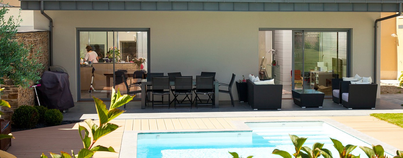 Grandes baies vitrées ouvertes au bord de terrasse et piscine